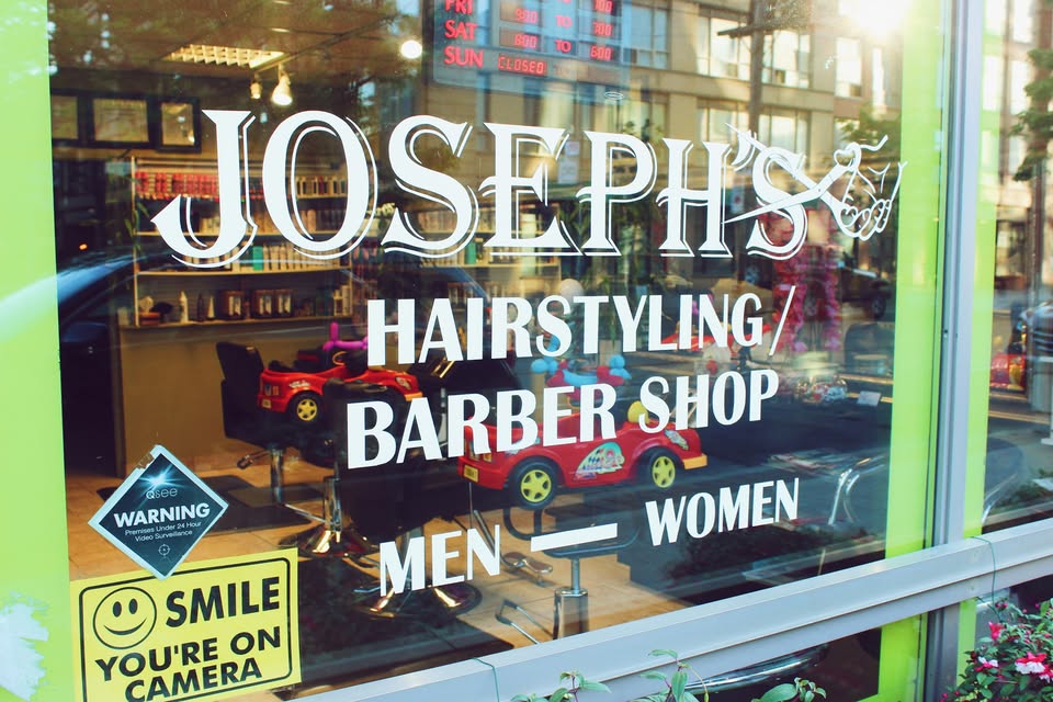 Joseph’s green shop window on Queen Street East, with barber chairs and children’s car chairs inside.
